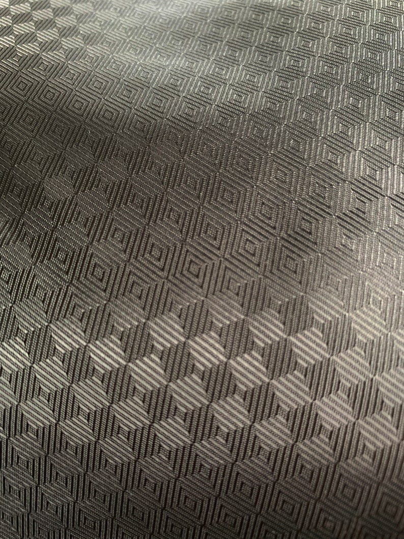 May include: Black fabric with a geometric pattern of small squares.