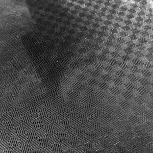 May include: Black and white checkered fabric with a textured surface.