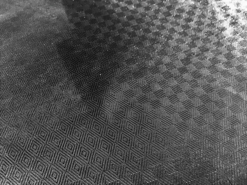 May include: Black and white checkered fabric with a textured surface.