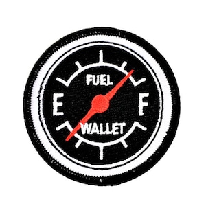 Könnte beinhalten: Schwarz-weißes Tankanzeige-Patch mit einem roten Zeiger, der auf "F" für "Voll" zeigt, und dem Text "FUEL WALLET".