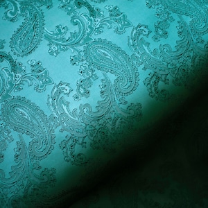 May include: Teal fabric with a paisley pattern. The fabric has a soft, velvety texture.