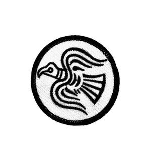 May include: Black and white embroidered patch of a stylized raven in flight, on a white circular background.