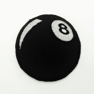 May include: Black and white embroidered patch of a billiard ball with the number 8 on it.