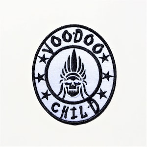 May include: Black and white embroidered patch with the text "Voodoo Child" in a circle around a skull wearing a headdress with feathers.
