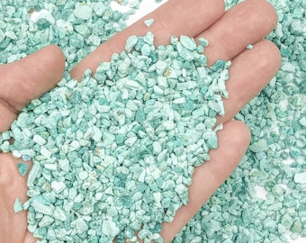 Può includere: Una manciata di piccole schegge di turchese verde chiaro. Le schegge sono di forma e dimensioni irregolari e hanno una texture leggermente ruvida.