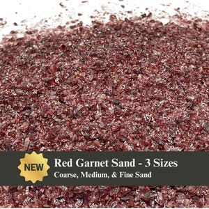 May include: Close-up of red garnet sand in coarse, medium, and fine sizes. The sand is a deep reddish-purple color and appears to be made of small, irregular pieces. Text on the image reads "Red Garnet Sand - 3 Sizes" and "Coarse, Medium, & Fine Sand."
