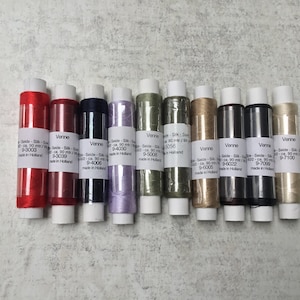 May include: Ten spools of Venne silk thread in a range of colours, such as red, black, and gold. Each spool is labelled with a product code and the text "made in Holland."