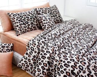 Puede incluir: Un juego de cama de estampado de leopardo con un edredón, dos almohadas estándar y dos almohadas decorativas. La ropa de cama está hecha de tela suave y felpa y presenta un estampado de leopardo audaz en tonos de marrón, negro y blanco.