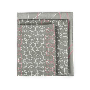 May include: Three grey fabric napkins with a white and pink geometric pattern. The napkins are folded on top of each other.