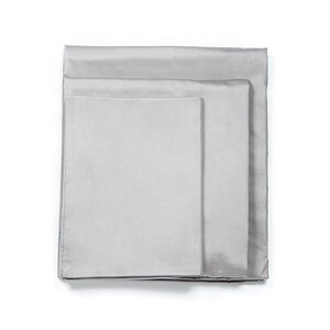 May include: A set of three gray fitted sheets, folded and stacked on top of each other.