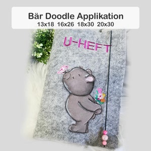 May include: A gray felt notebook cover with a pink butterfly, a gray bear with a bouquet of flowers, and the text "U-HEFT" embroidered in pink. The cover is available in sizes 13x18, 16x26, 18x30, and 20x30 inches.