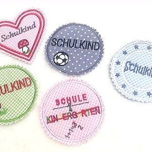 May include: Five embroidered iron-on patches with different designs. The patches are all white with different colored accents. The patches say "Schulkind" which is German for "school child". One patch has a soccer ball, one has a mushroom, one has a heart, one has stars, and one has a schoolhouse.