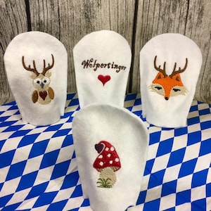 Könnte beinhalten: Vier weiße Filz-Fingerpuppen mit gestickten Designs. Die Puppen zeigen eine Eule, einen Fuchs, einen Pilz und den Text "Wolfperltinger" mit einem roten Herzen.