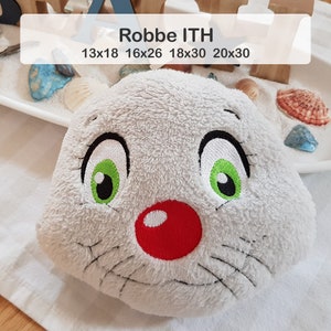 Könnte beinhalten: Ein graues Plüschtier mit einer roten Nase und grünen Augen. Das Spielzeug ist mit einem lächelnden Gesicht und Schnurrhaaren bestickt. Der Text "Robbe ITH 13x18 16x26 18x30 20x30" ist über dem Spielzeug gedruckt.