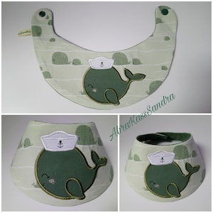 May include: Three green and white fabric baby bibs with a whale wearing a sailor hat design. The bibs are made of a soft, absorbent material and are perfect for keeping baby's clothes clean during mealtime.