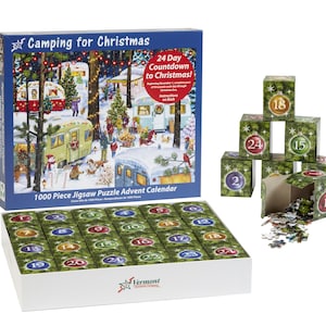 May include: A 1000 piece jigsaw puzzle advent calendar with a Christmas camping theme. The box features a colorful illustration of campers in a snowy forest with Christmas lights. The puzzle pieces are arranged in a box with 24 numbered compartments. The box also includes a set of 24 small boxes, each containing a piece of the puzzle. The boxes are stacked in a pyramid shape, with the top box containing the number 18. The boxes are decorated with a green and white Christmas theme.