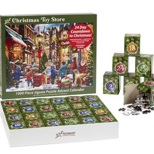 May include: A 1000 piece jigsaw puzzle advent calendar with a Christmas toy store scene. The box is open and the 24 individual puzzle pieces are visible. Each piece has a number from 1 to 24. The box also includes a small stack of 5 puzzle pieces with numbers 1, 2, 15, 18, and 24.