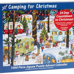 May include: A 1000 piece jigsaw puzzle advent calendar featuring a winter camping scene with Christmas lights, decorated campers, and a campfire. The box has the text "Camping for Christmas" and "24 Day Countdown to Christmas!"