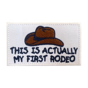 以下が含まれることがあります： 茶色のカウボーイハットと「This is actually my first rodeo.」というテキストが刺繍された白いパッチ