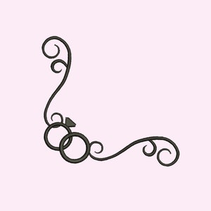 May include: Black and white wedding rings with a diamond on the top ring, surrounded by a decorative scroll design.