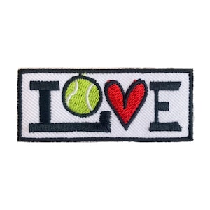 以下が含まれることがあります： 白地に黒文字で「LOVE」と刺繍されたパッチ。緑のテニスボールが「O」の代わり、赤いハートが「V」の代わりになっている。
