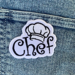 Può includere: Toppa da stirare ricamata bianca con un cappello da chef e la parola "chef" in corsivo.