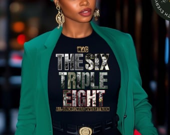 May include: A woman in a green blazer, black top, and leggings, with a green cap and gold jewellery. The black t-shirt displays "THE SIX TRIPLE EIGHT" in a layered design. She carries a black handbag and a red clutch. The image has a city backdrop.