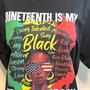 Puede incluir: Camiseta negra con un gráfico que celebra el Juneteenth. El diseño presenta a una mujer con gafas de sol con lentes de la bandera estadounidense, las palabras "Juneteenth is my Independence Day" y la palabra "Black".