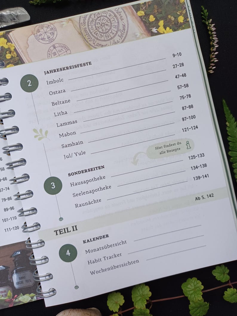 May include: A green and white planner with a spiral binding. The cover features a floral design and the text "JAHRESKREISFESTE" and "TEIL II". The planner includes sections for "Sonderseiten", "Kalender", "Monats&uuml;bersicht", "Habit Tracker", and "Wochen&uuml;bersichten".