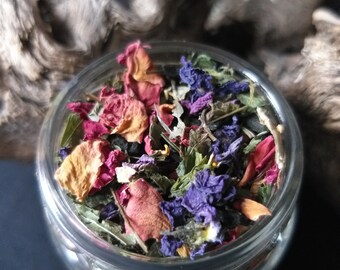 May include: A glass jar filled with a blend of dried herbs and flowers, including purple, pink, and orange petals.