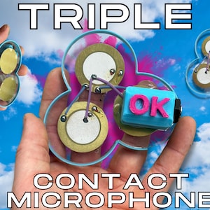 May include: A triple contact microphone with three gold-colored circular elements, connected by wires, and a blue and pink "OK" component. The device is held against a blue sky background with the words "TRIPLE CONTACT MICROPHONE" in white.