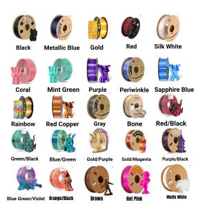 May include: A collection of 15 spools of filament for 3D printing, each with a different color and name. The colors include black, metallic blue, gold, red, silk white, coral, mint green, purple, periwinkle, sapphire blue, rainbow, red copper, gray, bone, red/black, green/black, blue/green, gold/purple, gold/magenta, purple/black, blue green/violet, orange/black, brown, hot pink, and matte white.