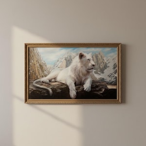 May include: A framed painting of a white lion resting on a log, set against a backdrop of snow-capped mountains and a blue sky. The lion has a full mane and is gazing to the right. The frame is gold with ornate detailing.