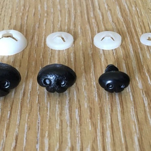 May include: Assortment of black plastic safety eyes and noses for stuffed animals. The eyes come in two sizes and the noses have a textured surface.
