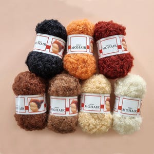 Puede incluir: Ocho carretes de hilo de mohair para muñecas en varios colores, incluyendo negro, naranja, rojo, marrón y crema. Cada carrete tiene una etiqueta que dice "Doll Mohair".