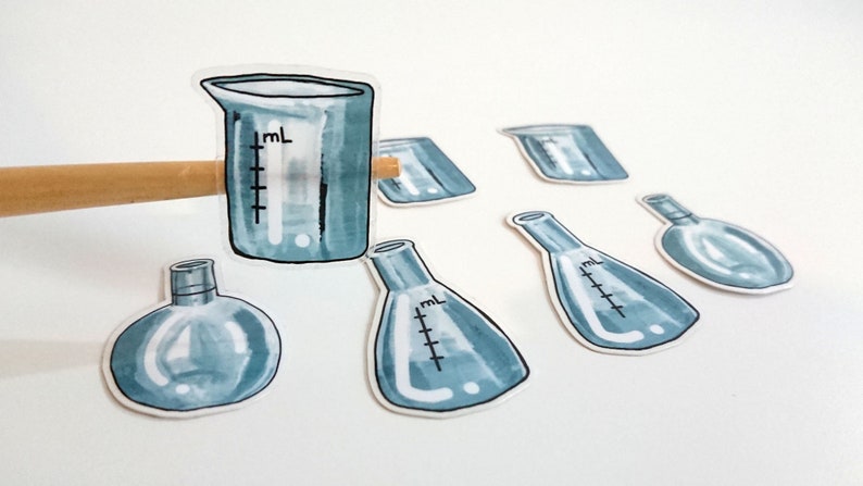 May include: A set of seven blue glass laboratory beakers and flasks with markings for measuring liquids. The beakers and flasks are arranged on a white surface.
