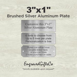 May include: A 3"x1" brushed silver aluminum plate with text stating: Customize this 3"x1" Silver Aluminum Plate, 6 fonts to choose from, Up to 5 lines per plate, Personalization is free, Plates can either have double-sided tape, or 2 holes punched.