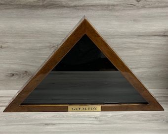 May include: A wooden triangular shadow box with a black background and a gold plaque that reads "GUY M. FOX".