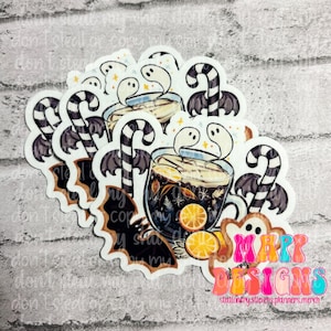 May include: A set of four Halloween-themed stickers featuring a mug of hot chocolate with orange slices, candy canes, and ghosts. The stickers are printed on white glossy paper and have a matte finish.