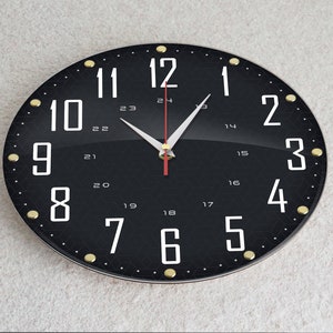 May include: A black clock with white numbers and gold accents. The clock face has a black background with a white grid pattern. The clock hands are white with a red second hand.