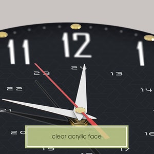 May include: A black clock with a clear acrylic face and gold accents. The clock has white numbers and a red second hand.