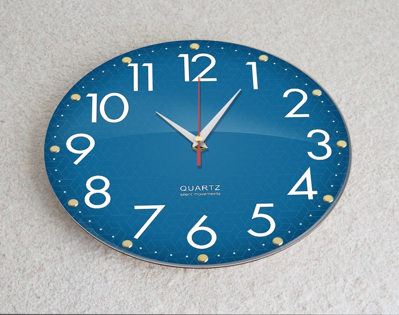 May include: A blue round clock with white numbers and gold accents. The clock face has a geometric pattern. The clock hands are white and red. The clock says "QUARTZ silent movements".