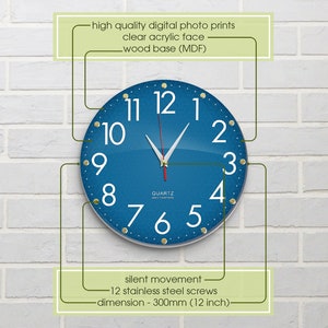 May include: A blue and white quartz wall clock with gold accents. The clock face is made of clear acrylic and has a wood base. The clock is 12 inches in diameter and has a silent movement.