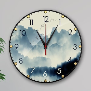 May include: A round wall clock with a black frame and gold accents. The clock face features a watercolor-style image of mountains and clouds in shades of blue and gray. The clock hands are black and red.