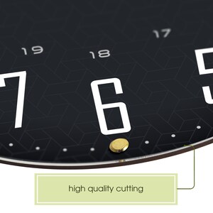 May include: Close-up of a black clock face with white numbers and gold accents. The numbers 17, 18, 19, and 20 are visible. The numbers 5, 6, and 7 are also visible. The clock face has a geometric pattern. The edge of the clock is brown.