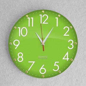 May include: A green round clock with white numbers and gold accents. The clock face has a sunburst design and the words "QUARTZ" and "QUARTZ MOVEMENT" are printed on the face.