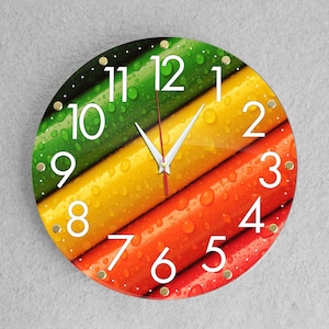 May include: A round clock with a colorful design of green, yellow, and red stripes. The clock face has white numbers and a black background. The clock hands are black and white.