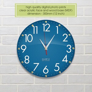 May include: A blue round clock with white numbers and gold accents. The clock is 12 inches in diameter and has a quartz movement.