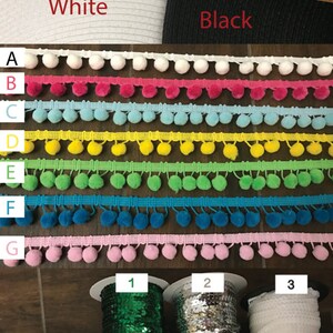 May include: Assortment of pom-pom trim and sequin trim in various colors. The trim is arranged in rows labeled A through G and 1 through 10. The colors include white, pink, blue, yellow, green, turquoise, gold, and silver.