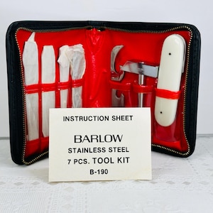 May include: A black leather case with a red interior holds a 7 piece stainless steel tool kit. The case has a zipper closure and the tools are visible through clear plastic windows. The instruction sheet reads "Barlow Stainless Steel 7 Pcs. Tool Kit B-190".